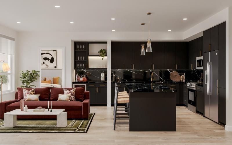 a black kitchen and a living room with a couch and a table