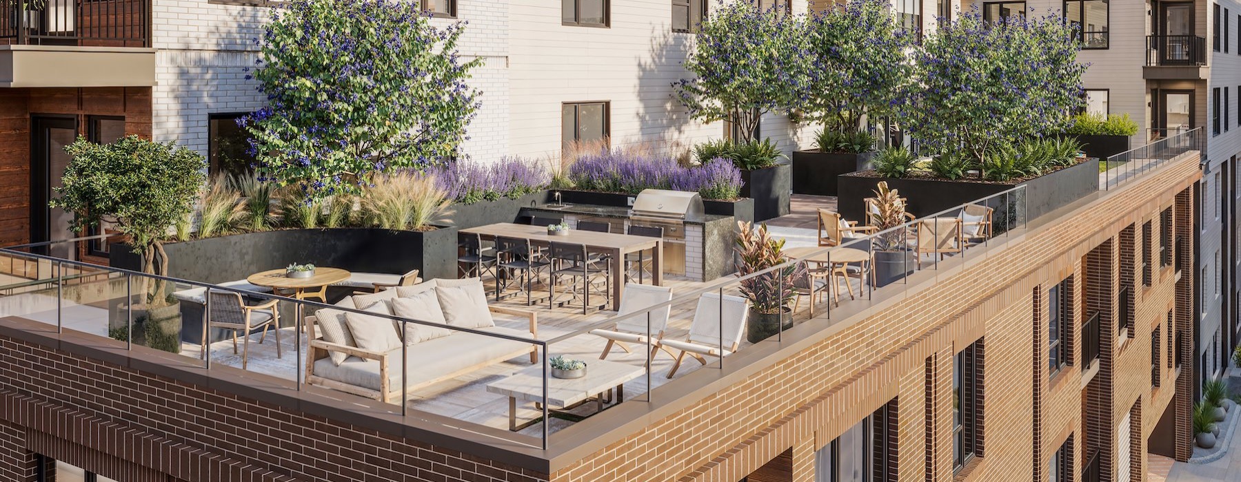 a rooftop patio with couches, tables and chairs
