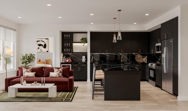 a black kitchen and a living room with a couch and a table