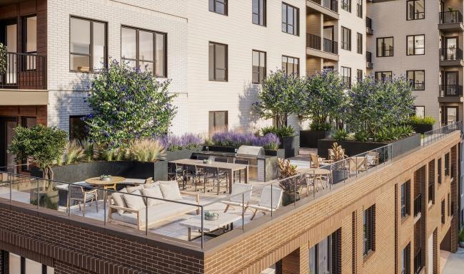 a rooftop patio with couches, tables and chairs